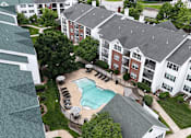 Thumbnail 17 of 19 - A large apartment complex with a pool in the middle.