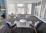 Thumbnail 10 of 18 - A living room with a grey couch, two chairs and a coffee table.