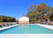 Thumbnail 16 of 18 - A swimming pool with a building in the background.