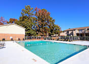Thumbnail 15 of 18 - A large swimming pool surrounded by trees and buildings.