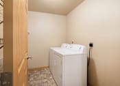 Thumbnail 12 of 29 - A white washing machine in a small room.