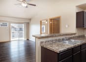 Thumbnail 6 of 29 - A kitchen with a marble countertop and a ceiling fan.