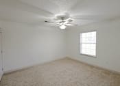 Thumbnail 9 of 20 - A room with a ceiling fan and a window.