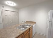 Thumbnail 2 of 20 - A kitchen with a sink and a refrigerator.