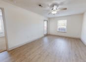 Thumbnail 4 of 17 - an empty living room with wood floors and a ceiling fan