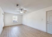 Thumbnail 3 of 17 - an empty Living room with white walls and a ceiling fan