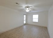 Thumbnail 10 of 20 - A room with a ceiling fan and two windows.