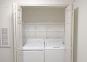 Thumbnail 3 of 20 - Two white front loading washing machines in a small laundry room.