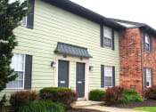 Thumbnail 34 of 35 - a green house with black doors and a red brick chimney
