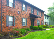 Thumbnail 33 of 35 - a brick apartment building with green grass and bushes in front of it