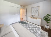 Thumbnail 10 of 23 - a bedroom with a bed and a plant and a closet
