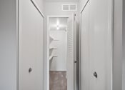 Thumbnail 12 of 23 - a closet in a small apartment with white doors and a white door to a bathroom