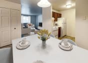 Thumbnail 1 of 23 - a dining room table with a vase of flowers    and a kitchen