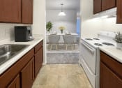 Thumbnail 3 of 23 - a kitchen with white appliances and a dining room with a table