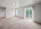 Thumbnail 2 of 23 - an empty living room with a sliding glass door to a balcony