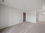 Thumbnail 6 of 23 - an empty living room with carpet and a door to a bedroom