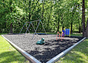 Thumbnail 22 of 26 - A playground with a swing set and a slide.