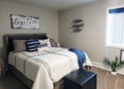 Thumbnail 5 of 8 - A bedroom with a bed, a bench, and a sign that says