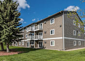 Thumbnail 8 of 8 - A large apartment building with a tree in front of it.
