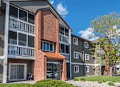 Thumbnail 7 of 8 - A modern apartment building with a red brick entrance.