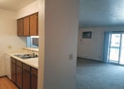 Thumbnail 1 of 8 - A kitchen with brown cabinets and a white sink.