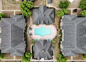 Thumbnail 25 of 33 - A bird's eye view of a neighborhood with a pool in the middle.