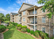 Thumbnail 26 of 33 - Apartment building with a green lawn in front.