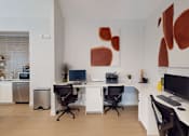 Thumbnail 10 of 33 - A modern home office with a large abstract painting on the wall.