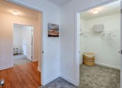 Thumbnail 4 of 33 - A room with a white door and a basket on the floor.