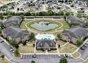 Thumbnail 32 of 33 - A bird's eye view of a residential area with a swimming pool and a pond.