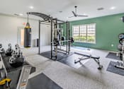 Thumbnail 14 of 33 - A gym with a green wall and a variety of equipment.