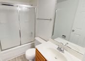 Thumbnail 11 of 23 - A white bathroom with a toilet, sink, and shower.