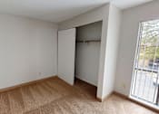 Thumbnail 10 of 23 - A room with a carpeted floor and a sliding door.