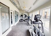 Thumbnail 15 of 23 - A gym with treadmills and elliptical machines.