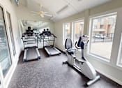 Thumbnail 16 of 23 - A room with a treadmill, elliptical trainer and a stationary bike.