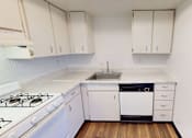 Thumbnail 7 of 23 - A kitchen with white cabinets and a white stove.