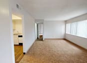 Thumbnail 3 of 23 - A room with a carpeted floor and a doorway leading to another room.
