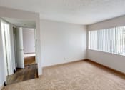 Thumbnail 2 of 23 - A room with a carpeted floor and a doorway leading to another room.