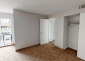 Thumbnail 8 of 23 - A room with a brown carpet and a white door.