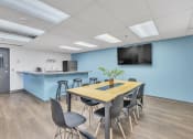 Thumbnail 15 of 16 - a conference room with a table and chairs with a kitchenette in the background