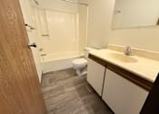 Thumbnail 13 of 16 - A bathroom with a toilet, sink, and bathtub.