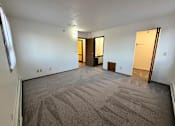 Thumbnail 9 of 16 - A room with carpeted floor and two doors.