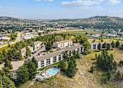 Thumbnail 10 of 11 - A large building with a pool in the foreground and a town in the background.