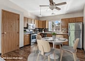 Thumbnail 1 of 11 - A kitchen with a table and chairs in the middle of the room.