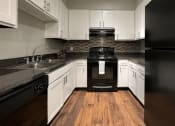 Thumbnail 7 of 29 - a kitchen with black appliances and white cabinets