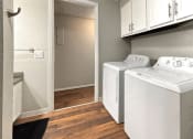 Thumbnail 17 of 29 - a laundry room with a washer and dryer and white cabinets