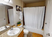 Thumbnail 15 of 35 - A bathroom with a sink, toilet, and shower.
