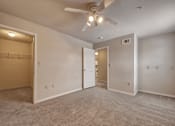 Thumbnail 13 of 35 - A spacious room with a ceiling fan and carpeted floor.