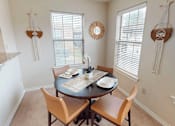 Thumbnail 2 of 35 - A dining room with a round table and chairs.