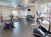 Thumbnail 19 of 35 - A gym with exercise equipment such as treadmills and stationary bikes.